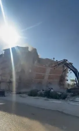 İş makinası, üzerine doğru yıkılan 6 katlı binanın altında kalmaktan saniyelerle kurtuldu