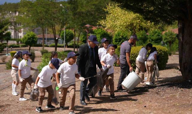 Parkı temizleyen görevlilere öğrenciler destek oldu